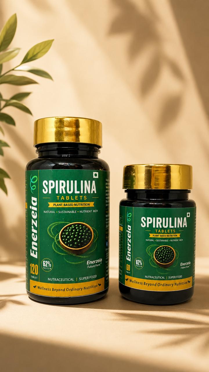 Two black and gold jars of Enerzeia Spirulina Tablets, 120 and 60 tablets, standing on a cream background beside a leaf shadow.